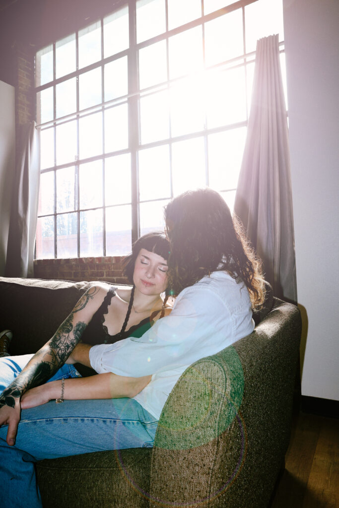alt couple cuddling on couch for photo session in downtown Springfield MO